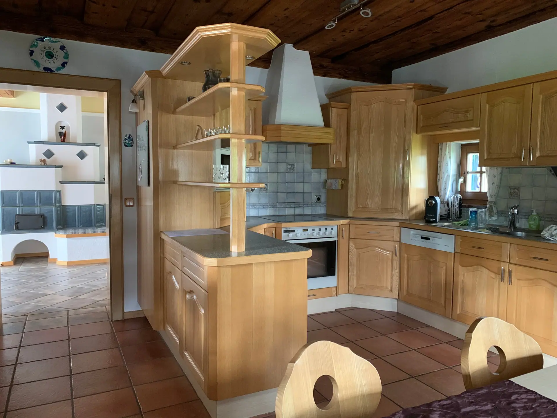 Küche aus hellem Holz mit Kochinsel, Backofen und Dunstabzug