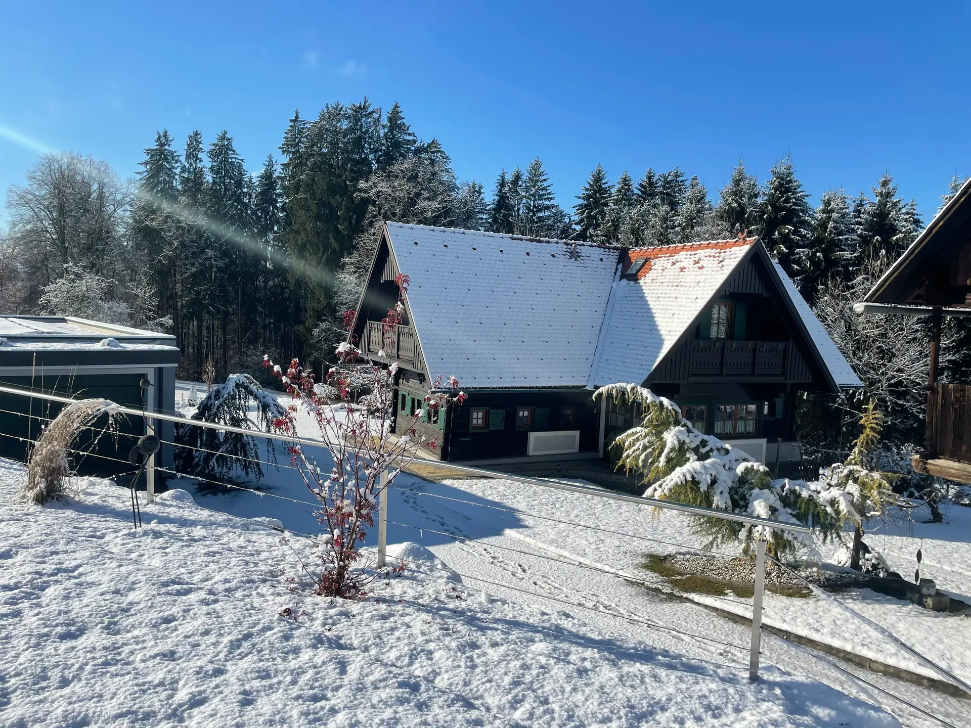 Das Haus im Winter mit verschneitem Dach und Garten